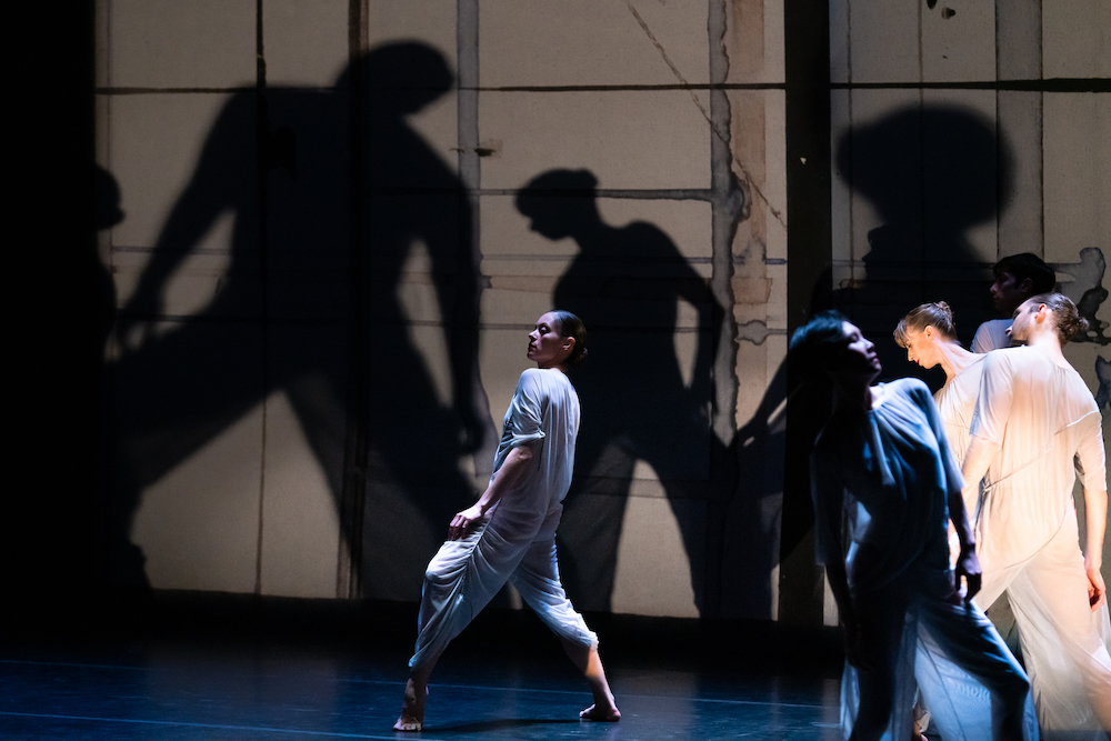 the dancers and their shadows appear to move together on stage